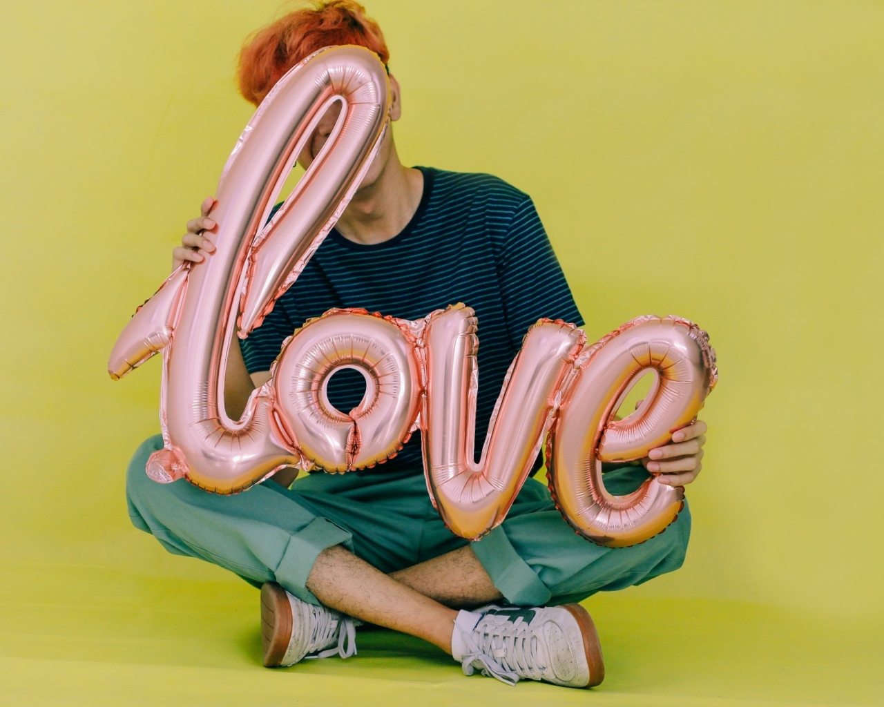 Мужчина держит шарики с надписью любовь