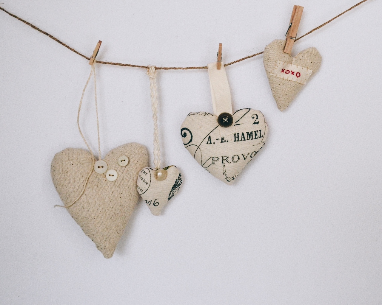 Сердечки из ткани на веревке на серой стене