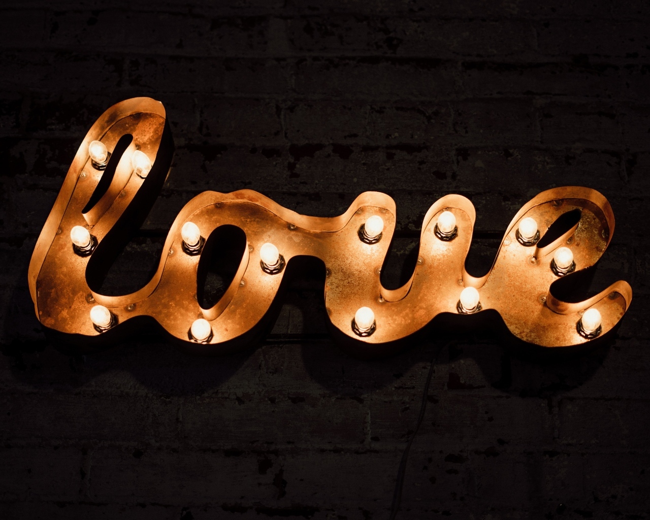 Светящаяся надпись любовь на черной стене