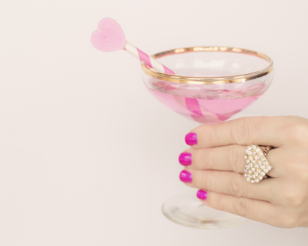 Кольцо в форме сердца на руке девушки с бокалом
