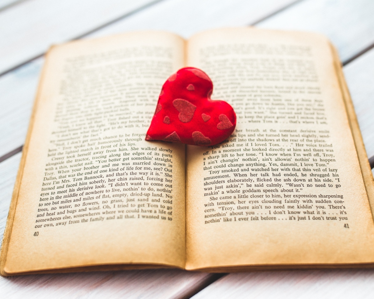 Маленькое красное сердце с книгой на столе