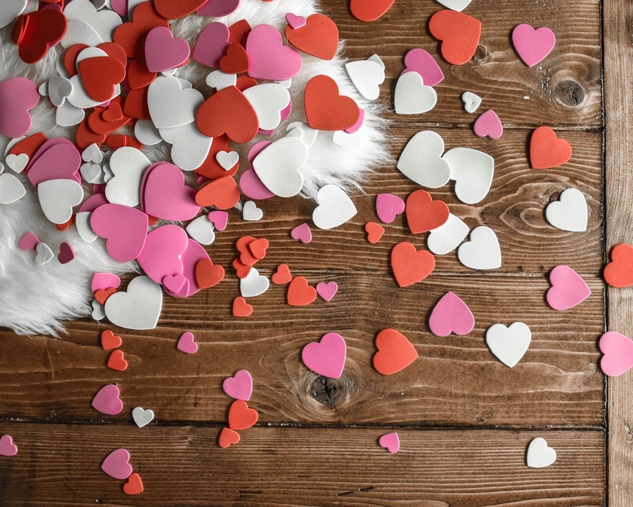 Много бумажных сердечек на деревянном полу