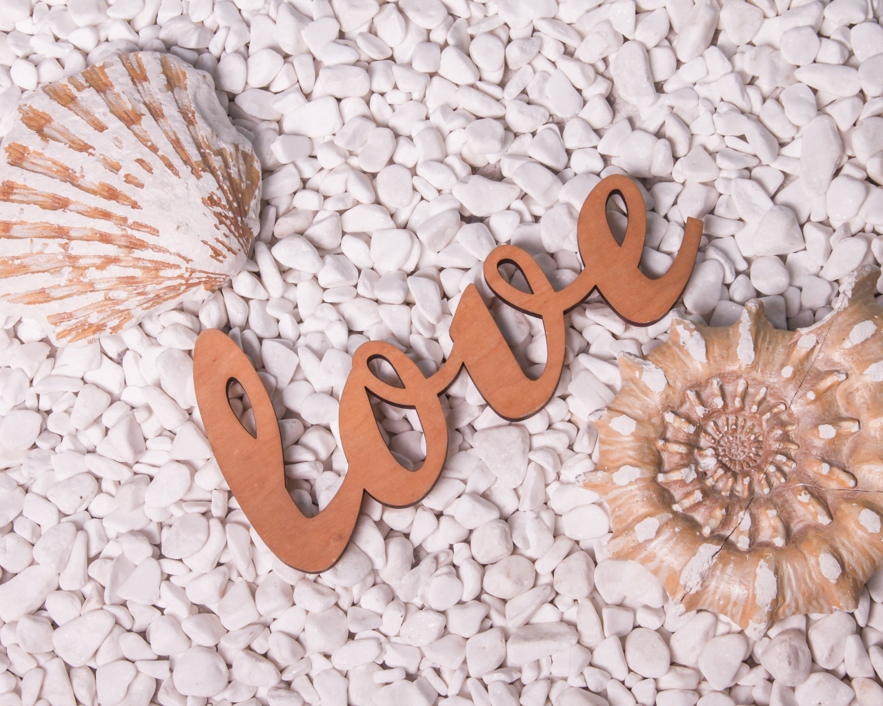 Ракушки и надпись любовь на белых камнях