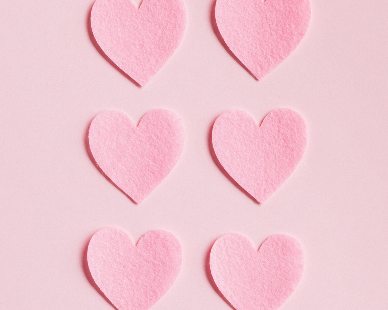 Маленькие бумажные сердечки на розовом фоне