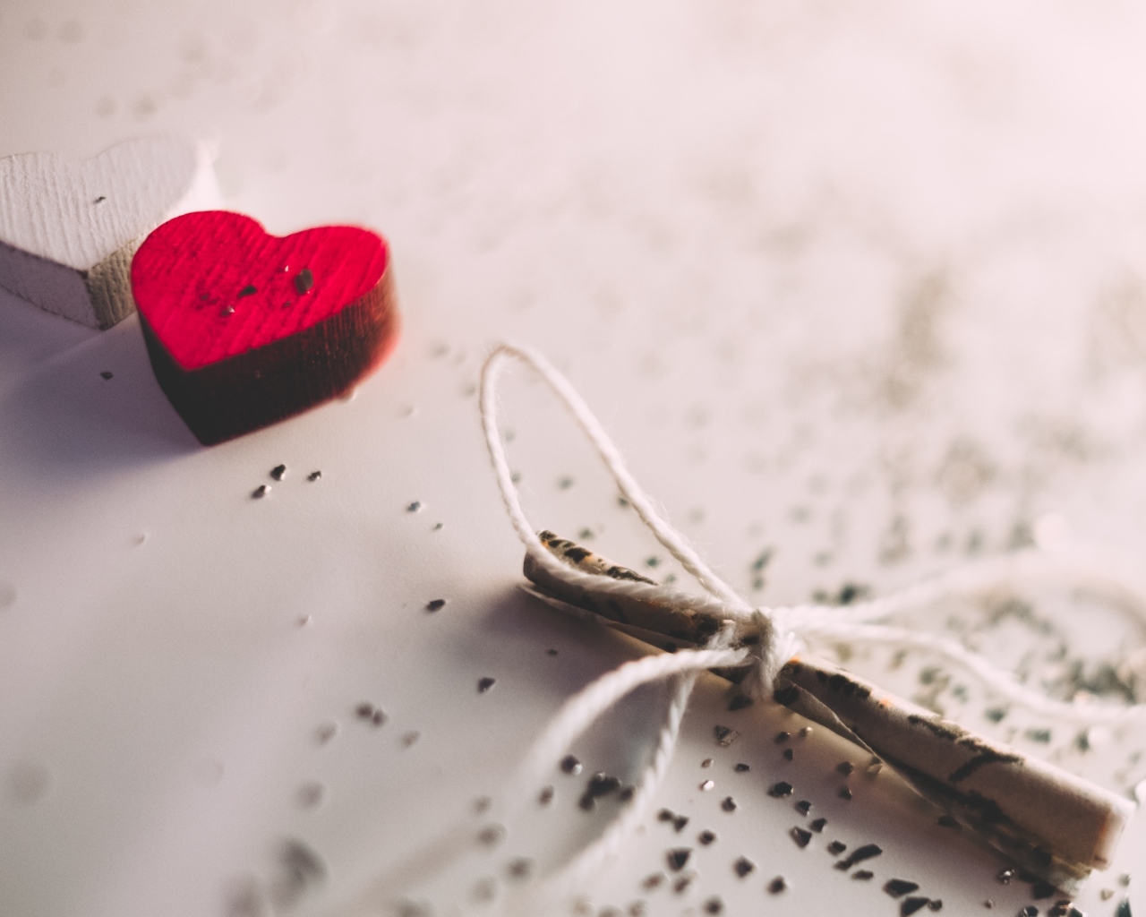 Два деревянных сердечка с запиской на столе