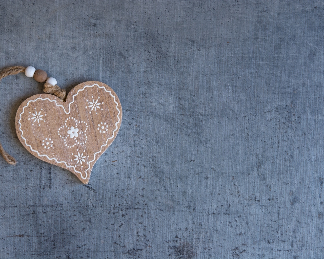 Деревянное сердце на нитке на сером фоне