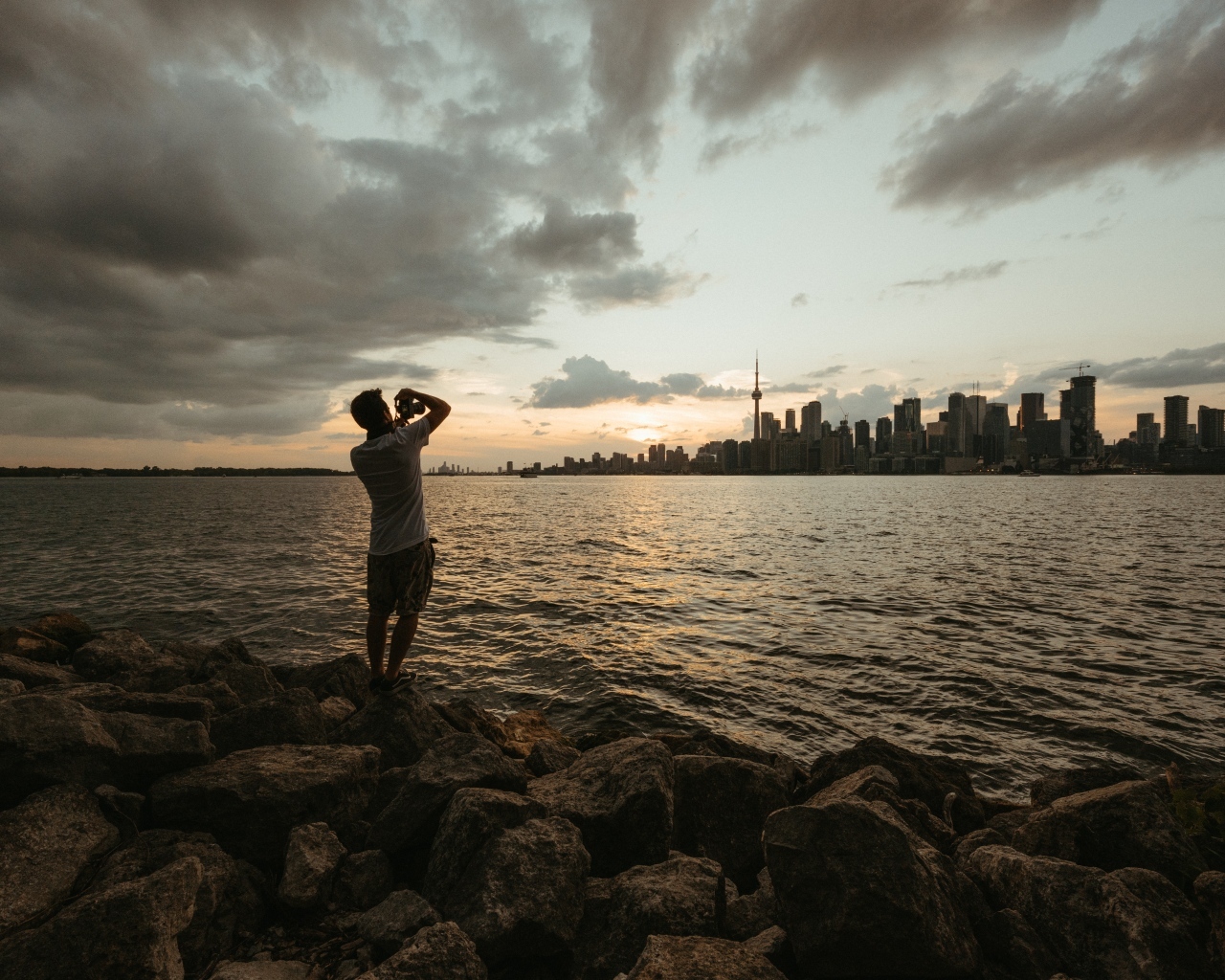 Мужчина делает фото города у моря