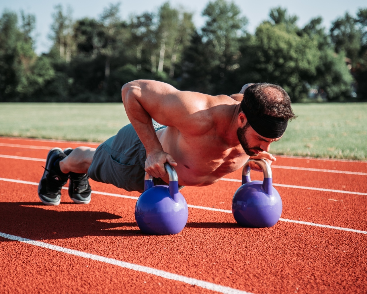 Мужчина спортсмен занимается с гирями