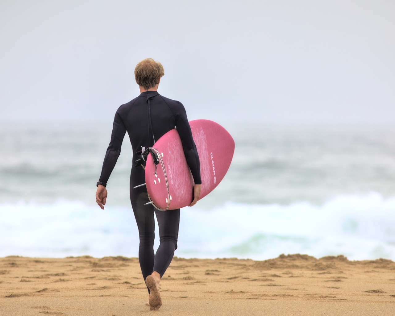 Мужчина серфингист идет к морю