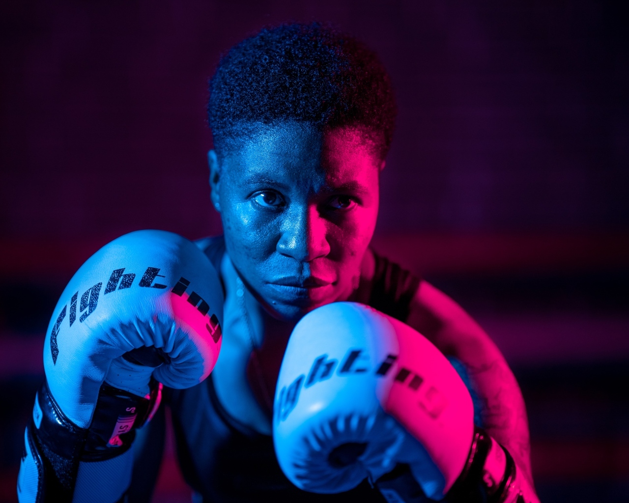Мужчина в боксерских перчатках на черном фоне