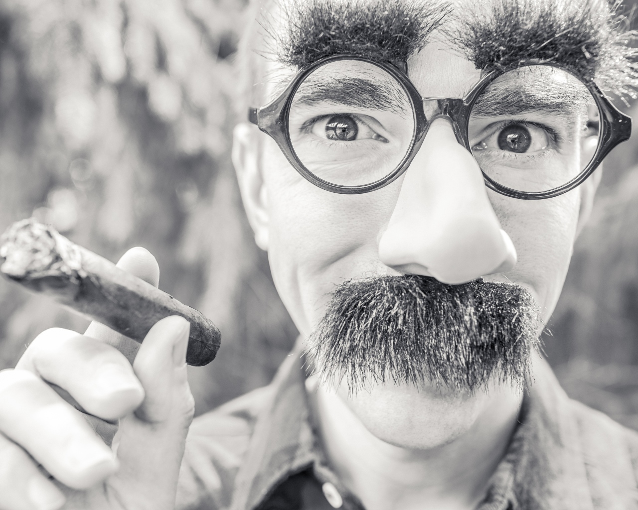 Мужчина в очках с сигарой в руке