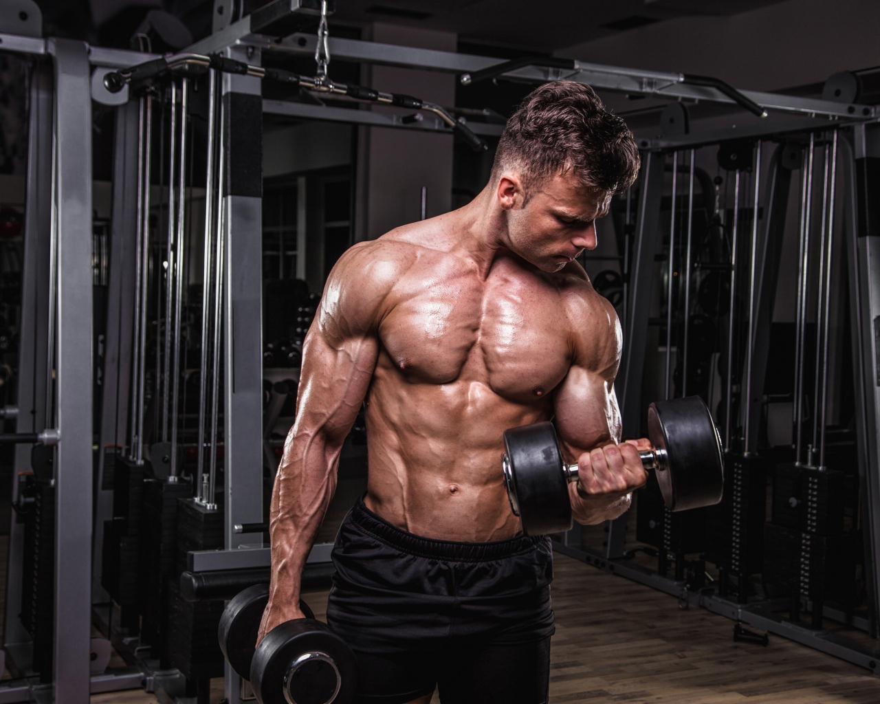 Сильный мужчина качает мускулы 