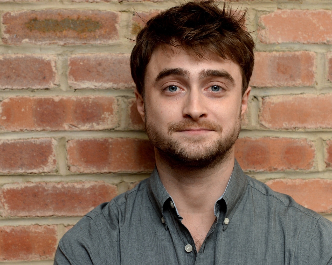 Актер Дэниел Рэдклифф стоит у стены