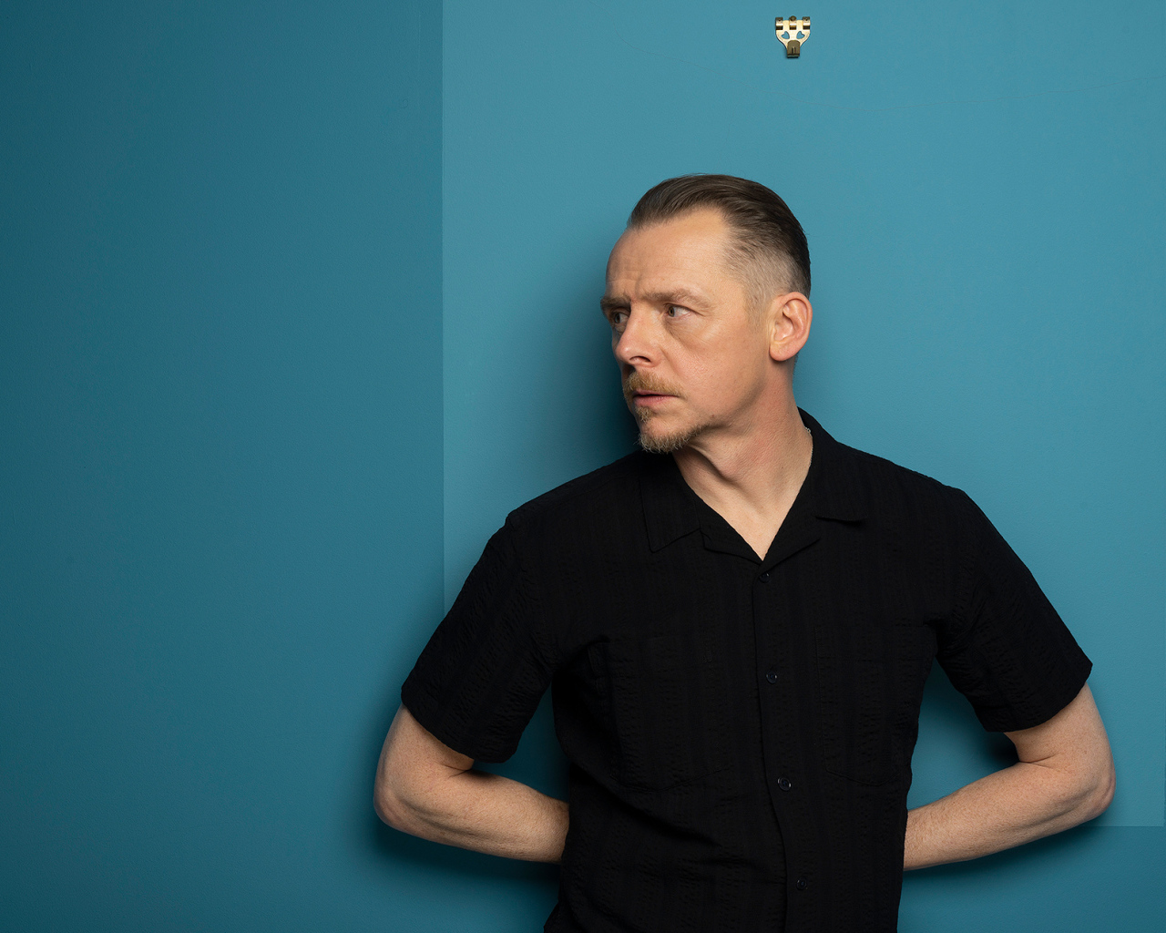 Актер Саймон Пегг  стоит у стены