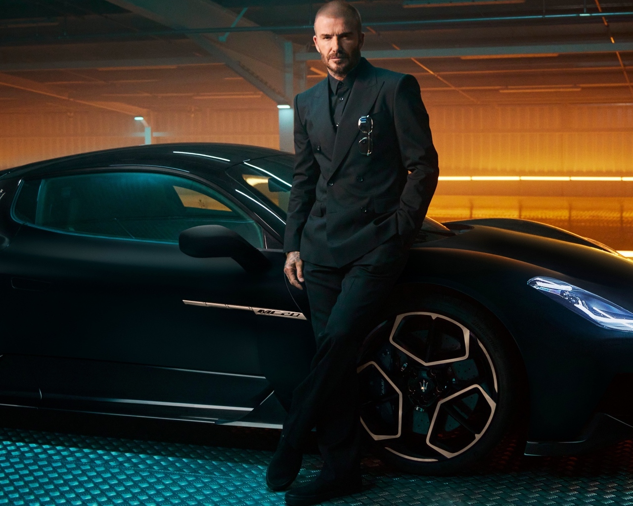 Футболист Дэвид Бекхэм у черного автомобиля Maserati MC20