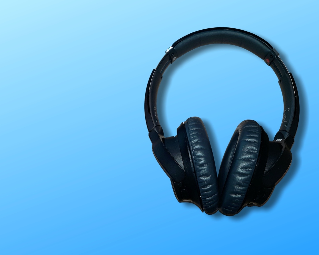 Большие черные наушники на голубом фоне