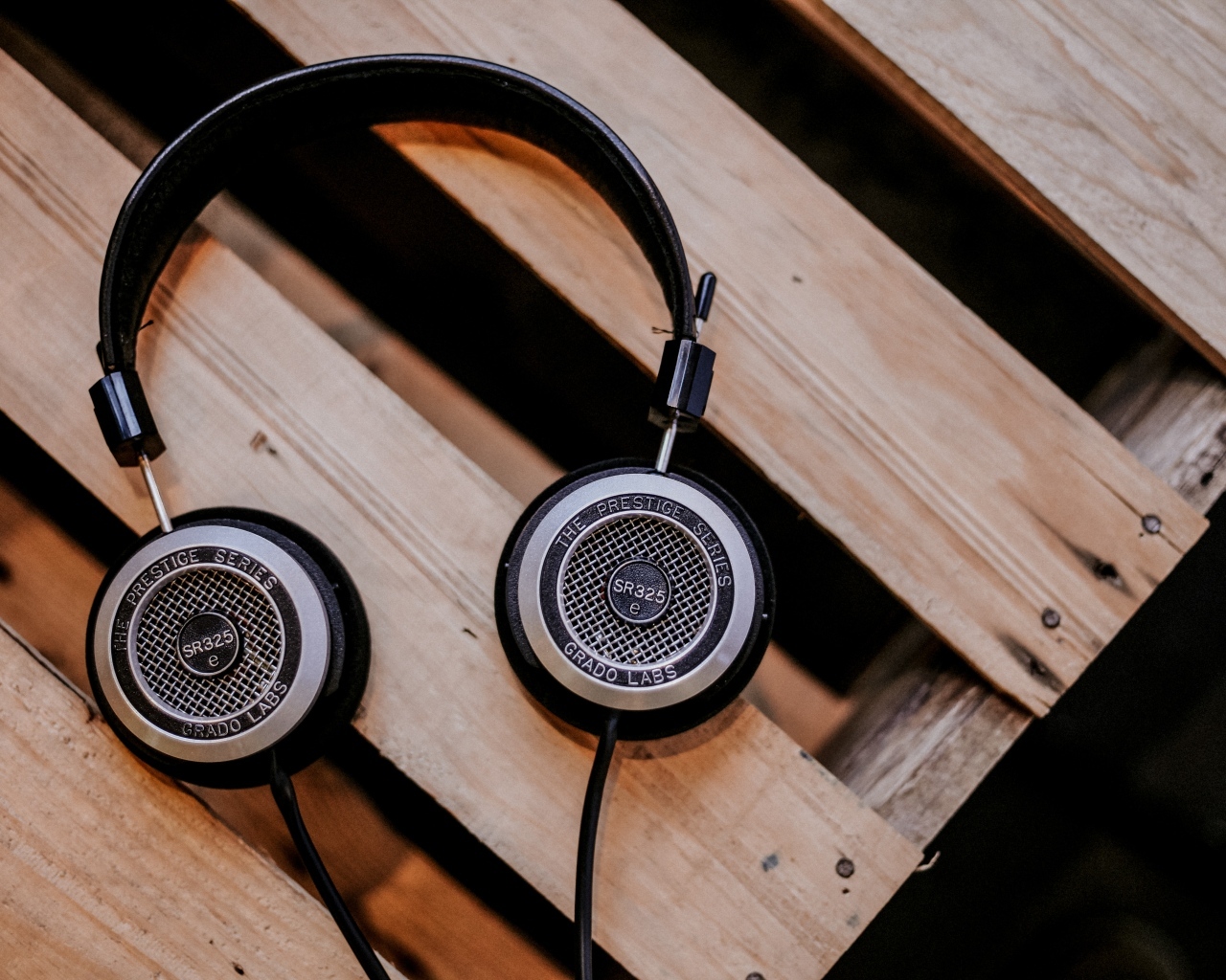 Старые наушники лежат на деревянной лавке