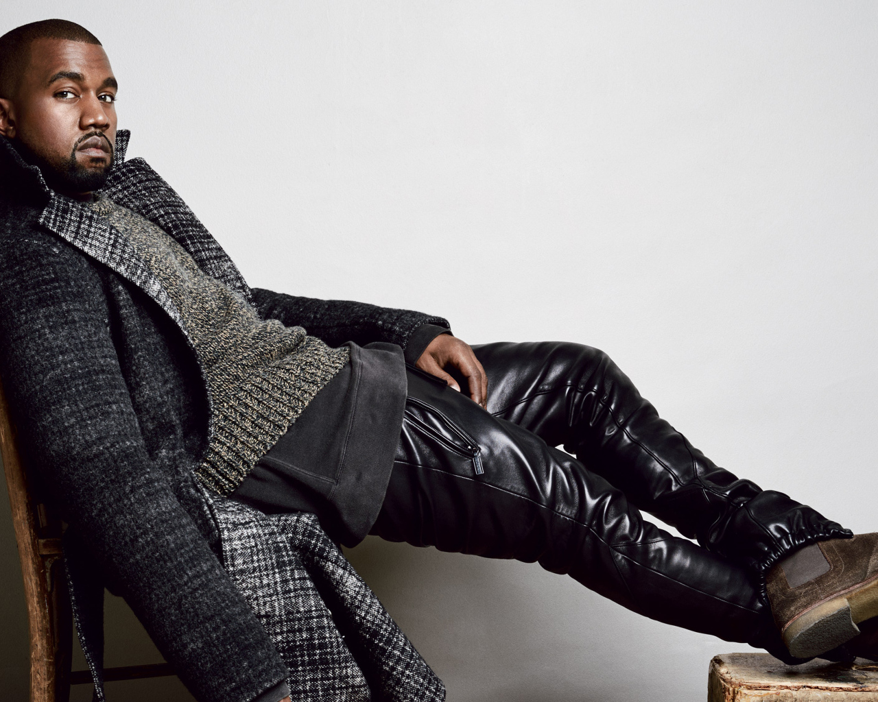 Рэпер Канье Уэст сидит на стуле