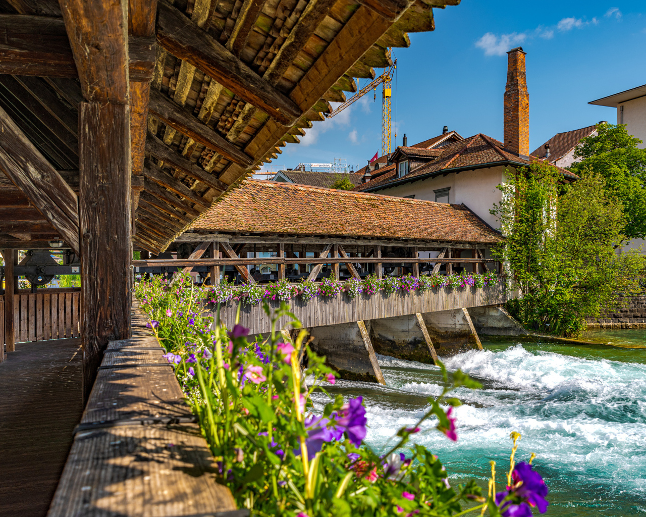 Красивый деревянный мост с цветами через реку