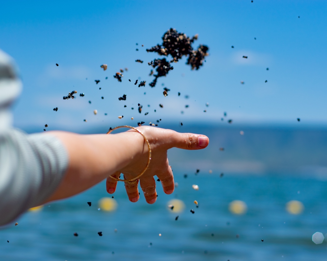 Девушка бросает корм в воду