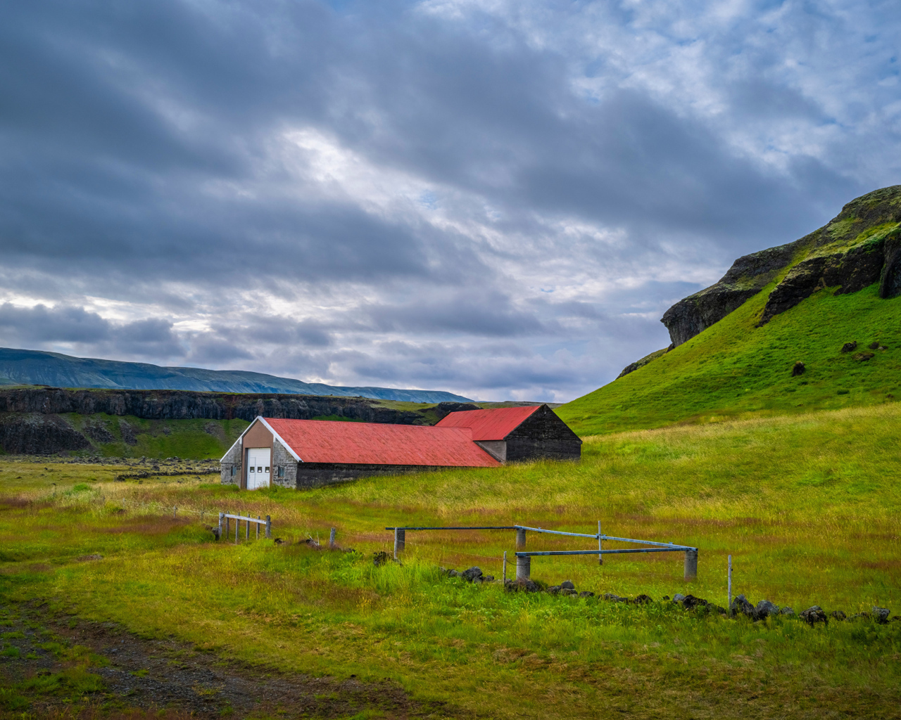 Дом у покрытой зеленью поры под грозовым небом