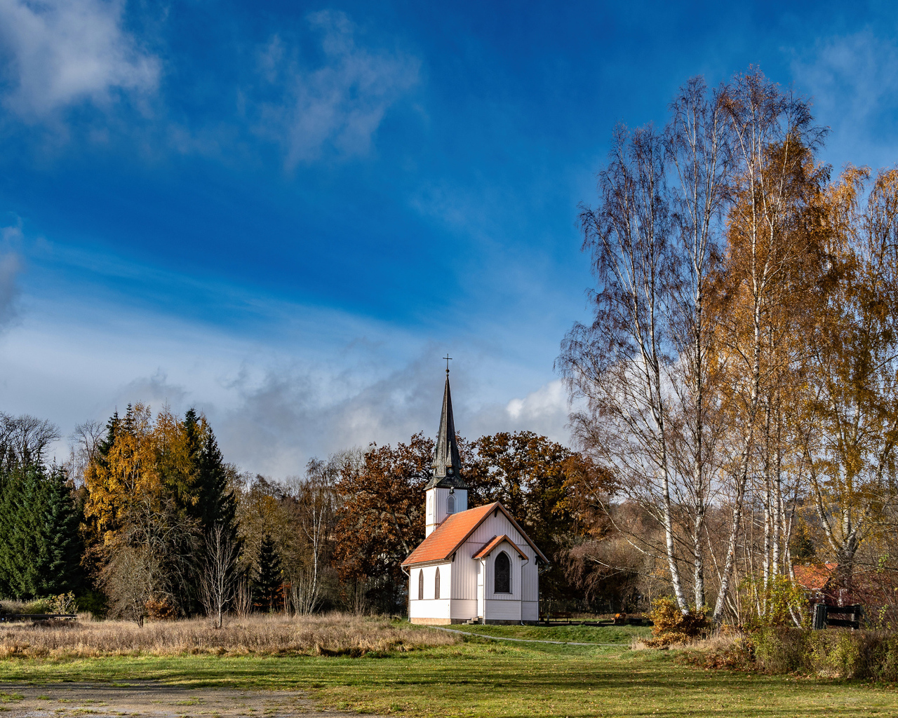 Старая часовня в парке под красивым голубым небом