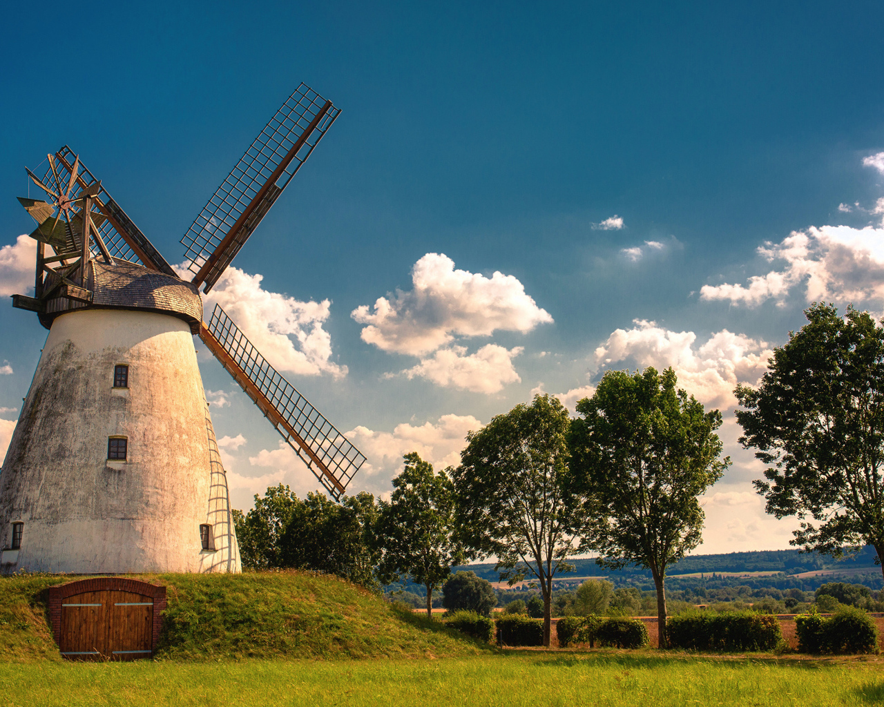 Старая мельница с зелеными деревьями