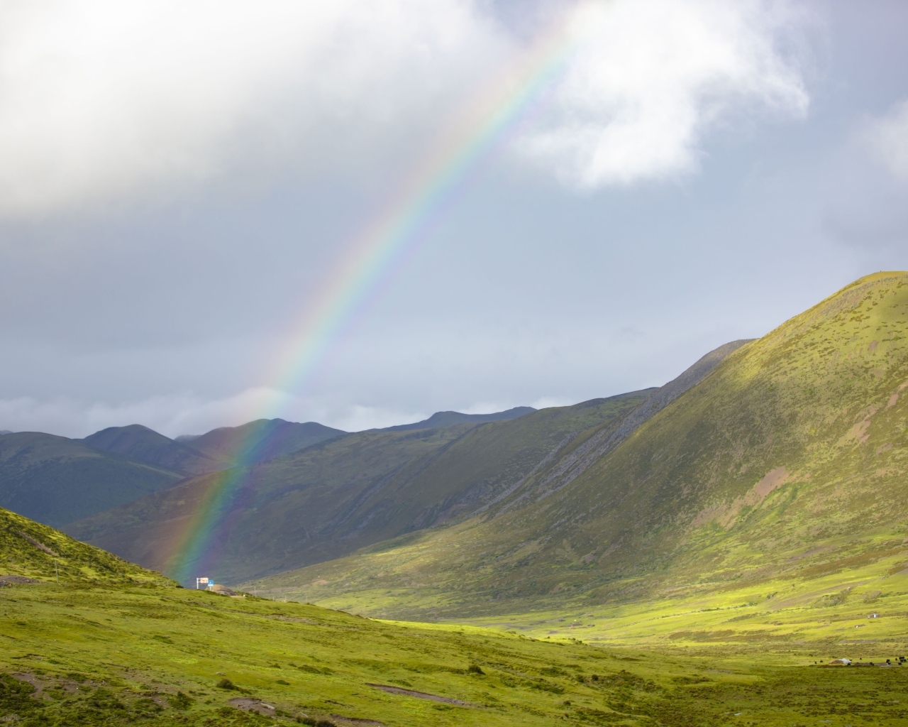 Радуга над покрытыми зеленью холмами