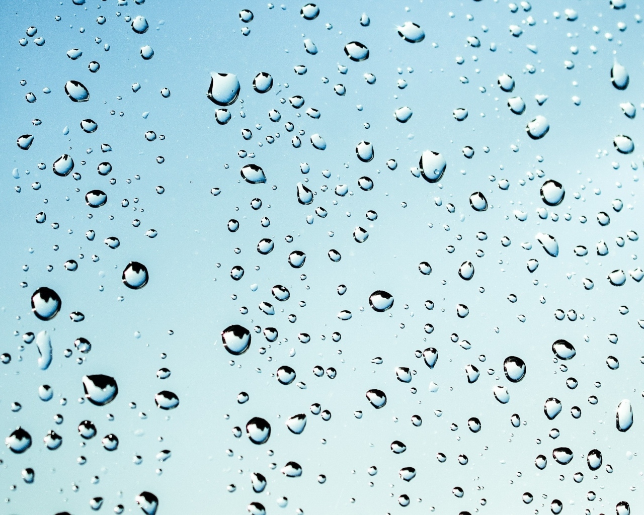 Капли дождя на голубом стекле
