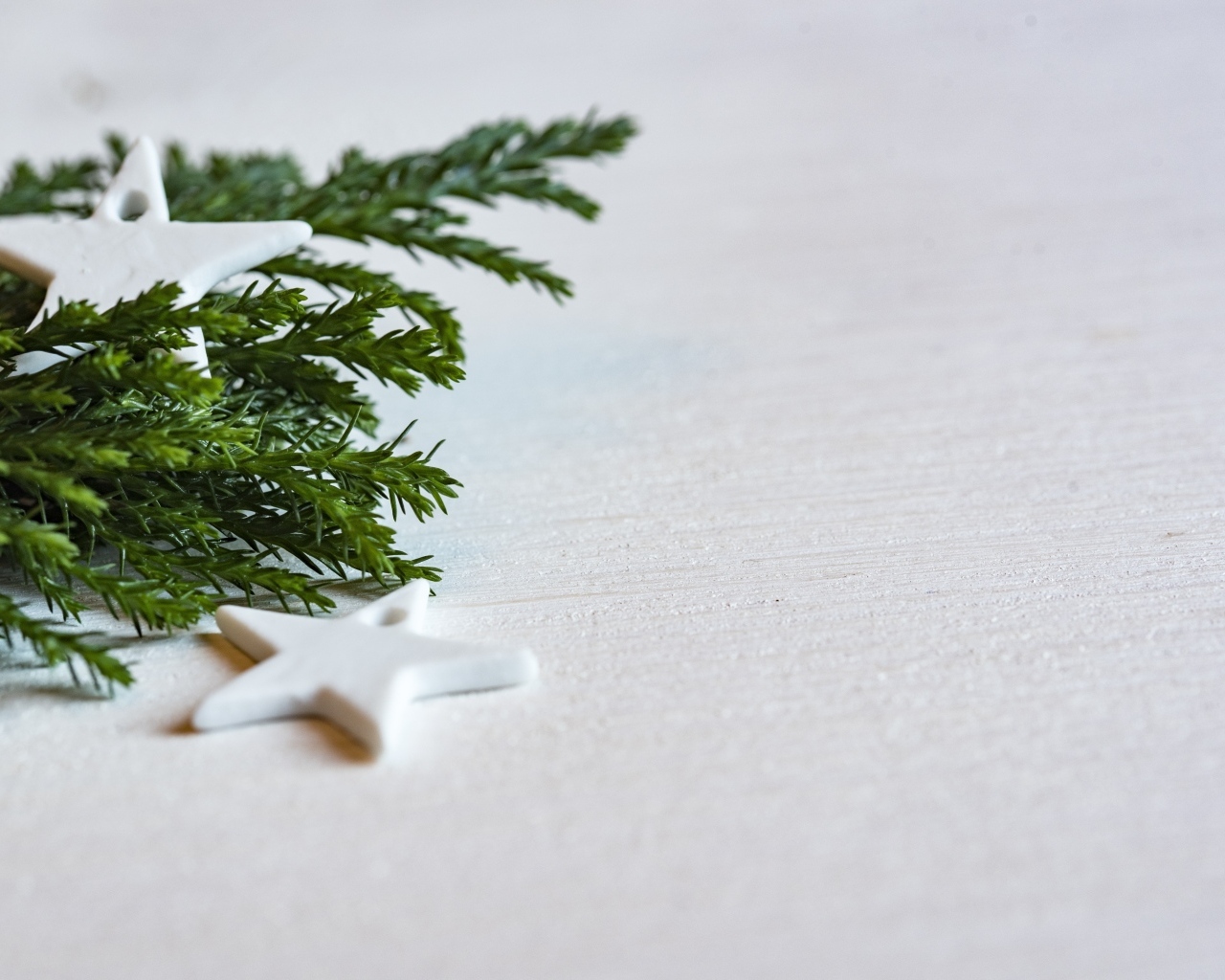 Звезды и ветка ели на белой поверхности 