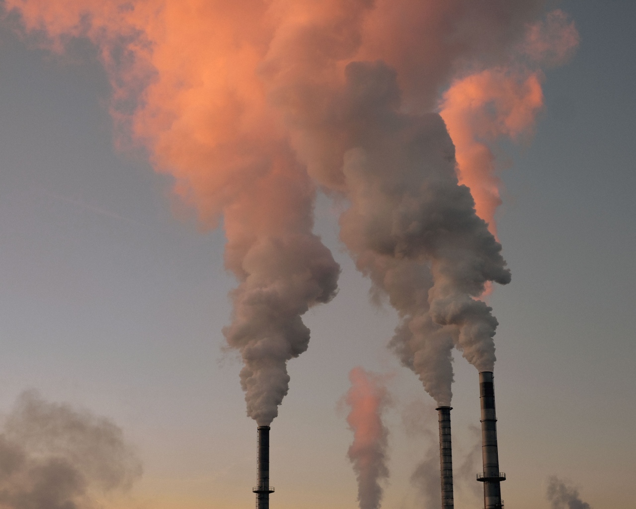 Густой белый дым идет из труб на заводе