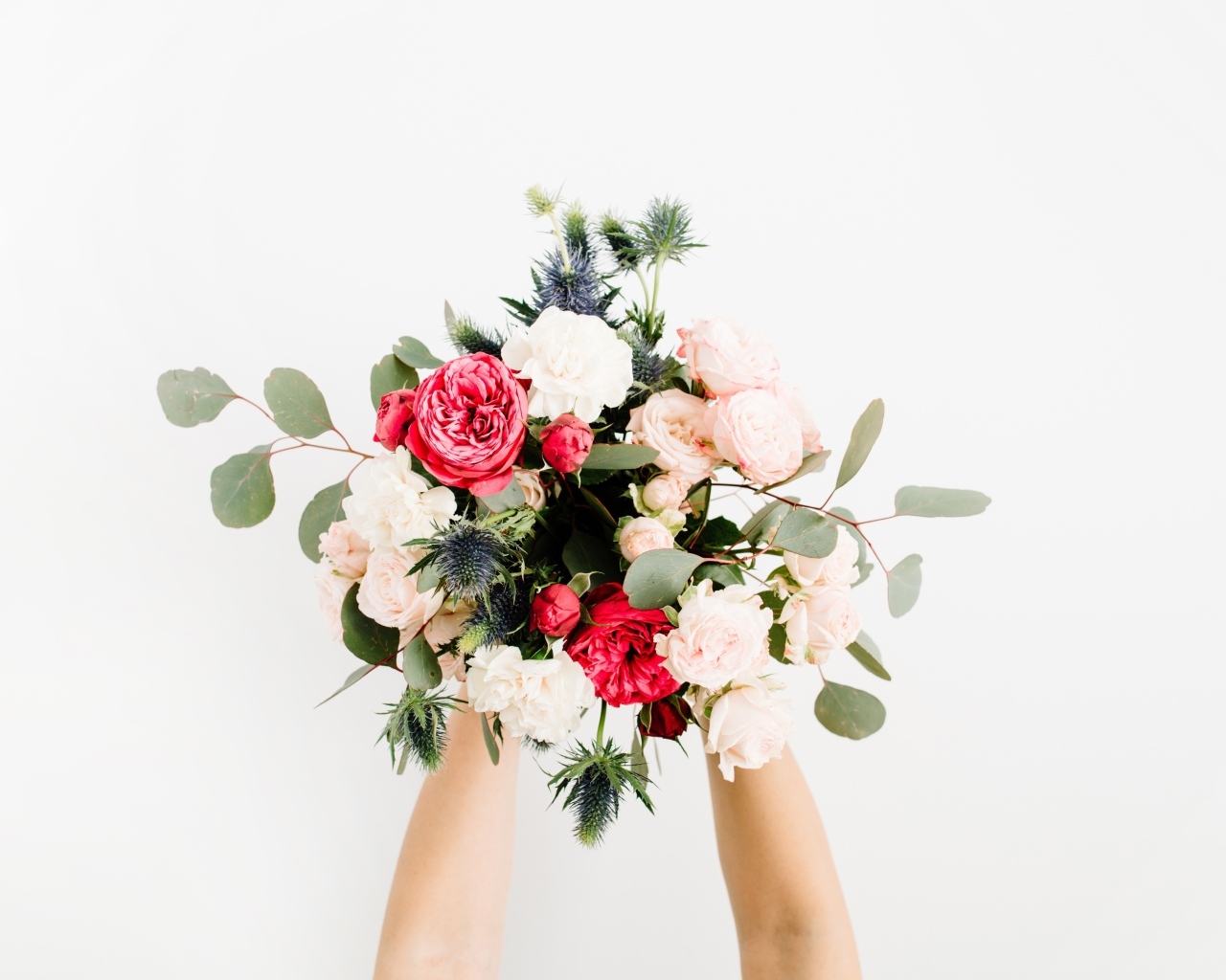 Букет цветов в руках у девушки на сером фоне