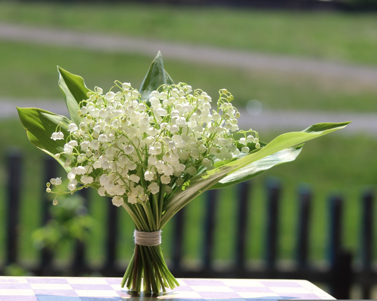 Красивый букет белых ландышей на столе в вазе