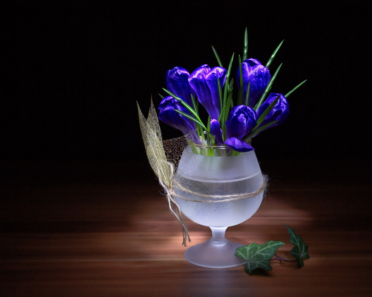 Синие крокусы в бокале на столе