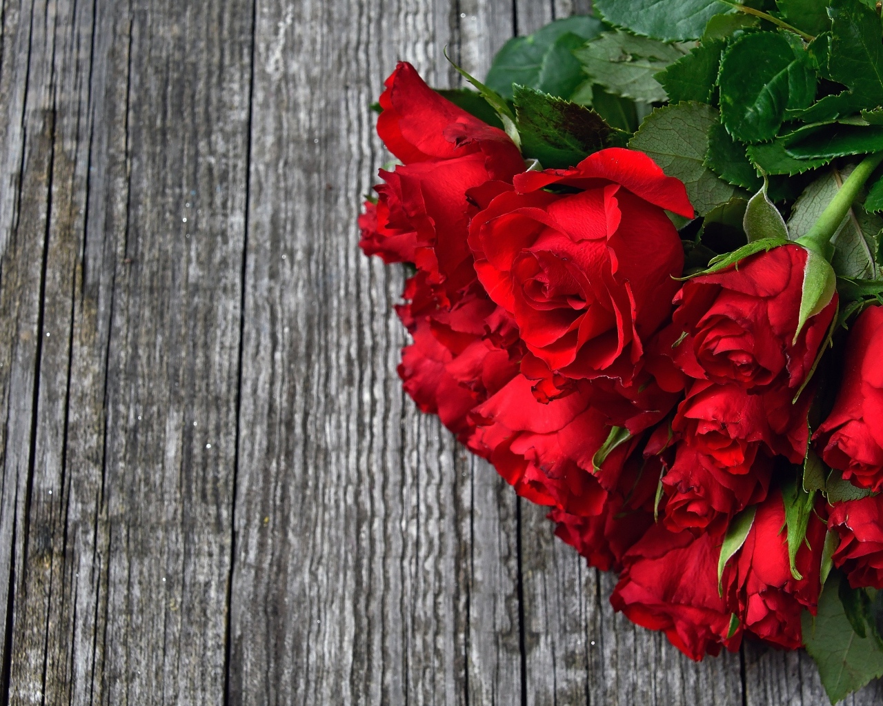 Букет красных роз на деревянном столе