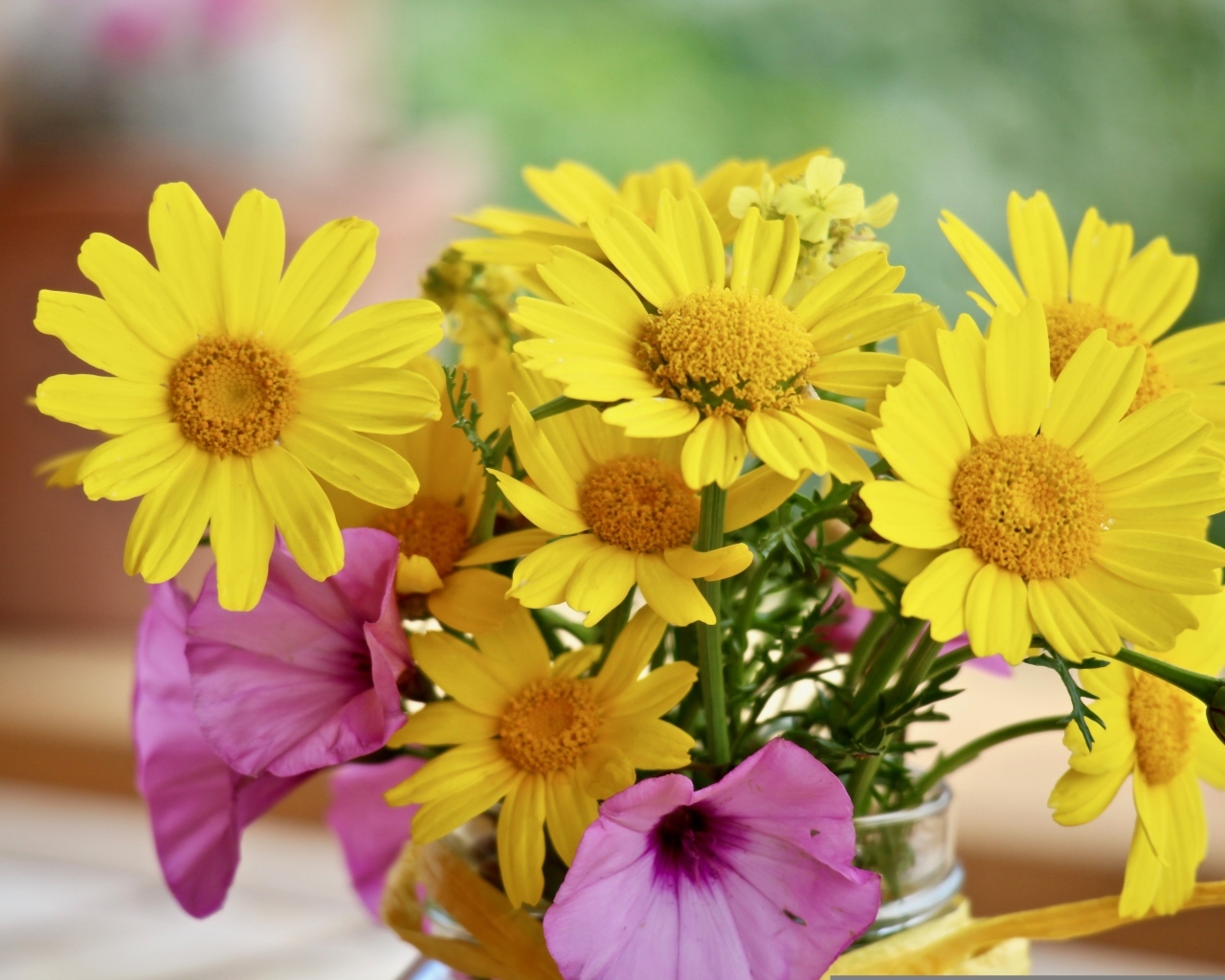 Букет желтых и розовых цветов в вазе на столе