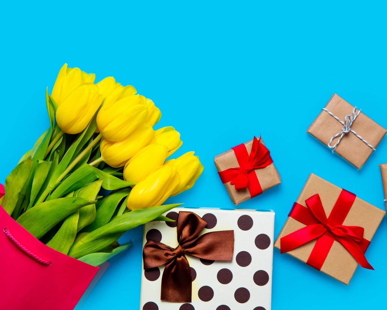 Букет желтых тюльпанов с подарками на голубом фоне