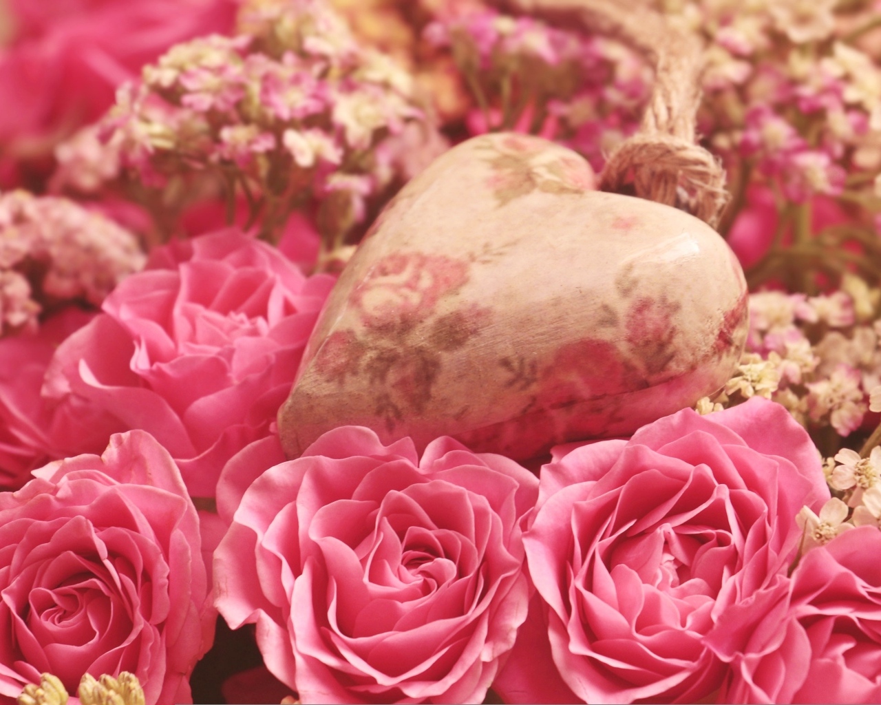 Сердце лежит на цветах розовой розы