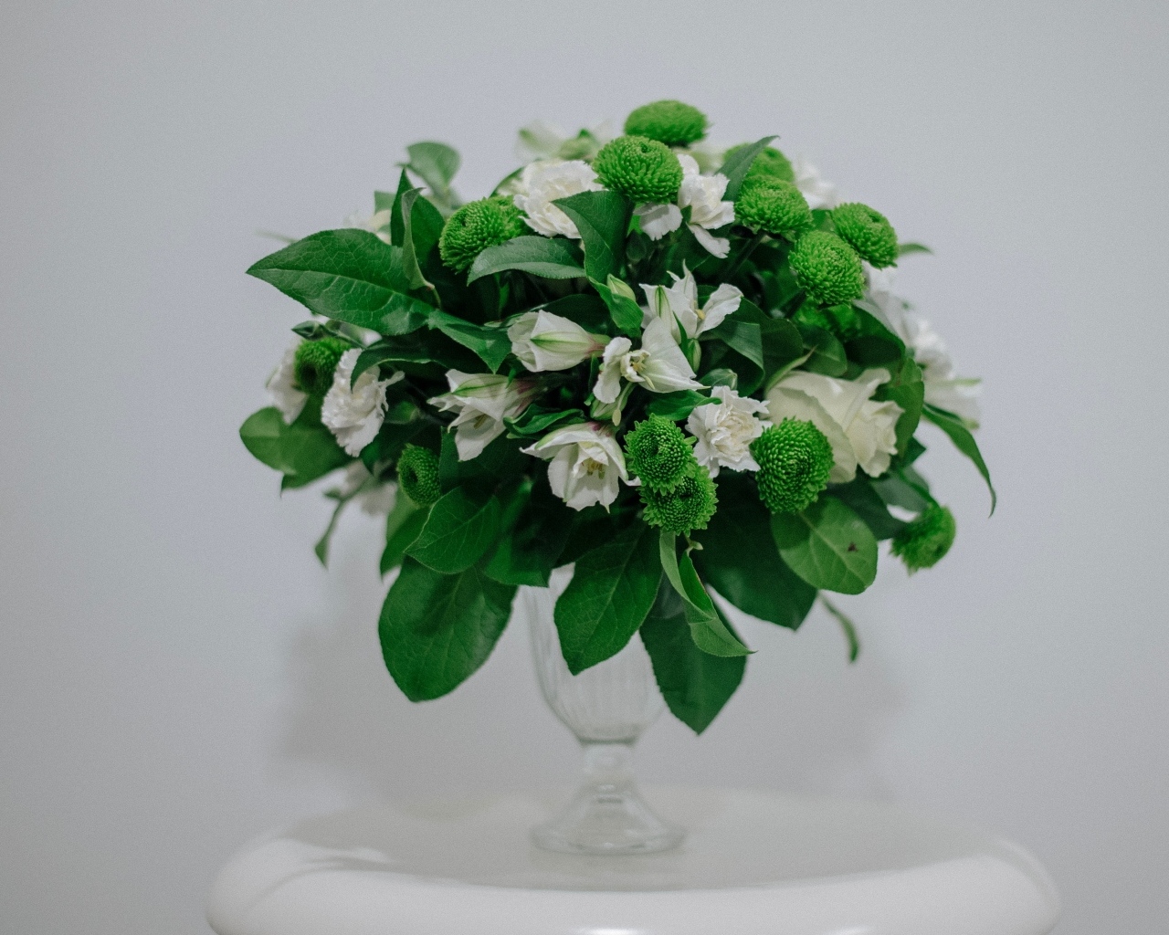 Белый букет с зелеными листьями на сером фоне