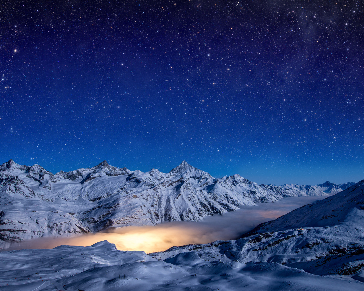 Красивое ночное небо над покрытыми снегом горами