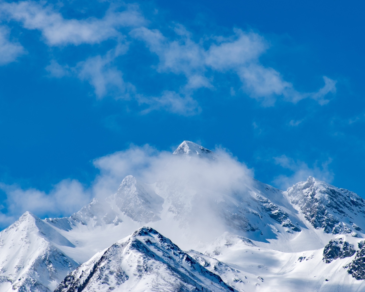 Голубое небо над покрытыми снегом горами