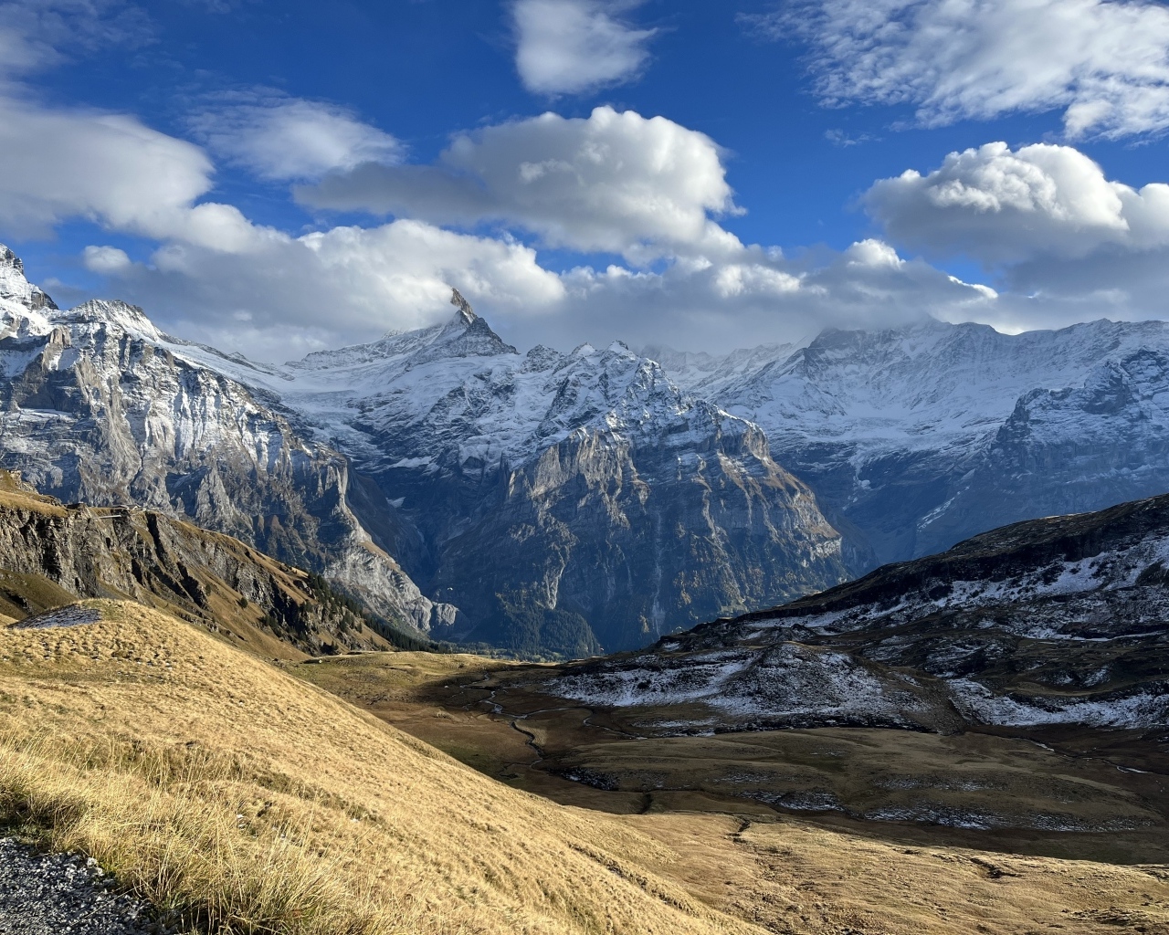 Высокие покрытые снегом горы в белых облаках