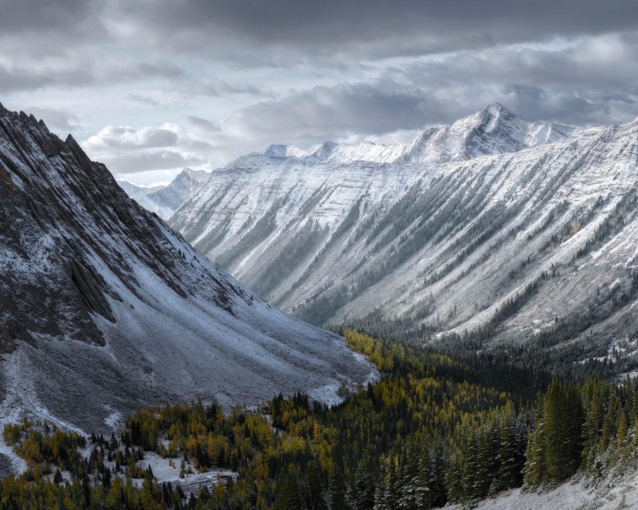 Покрытые снегом горы под грозовым небом