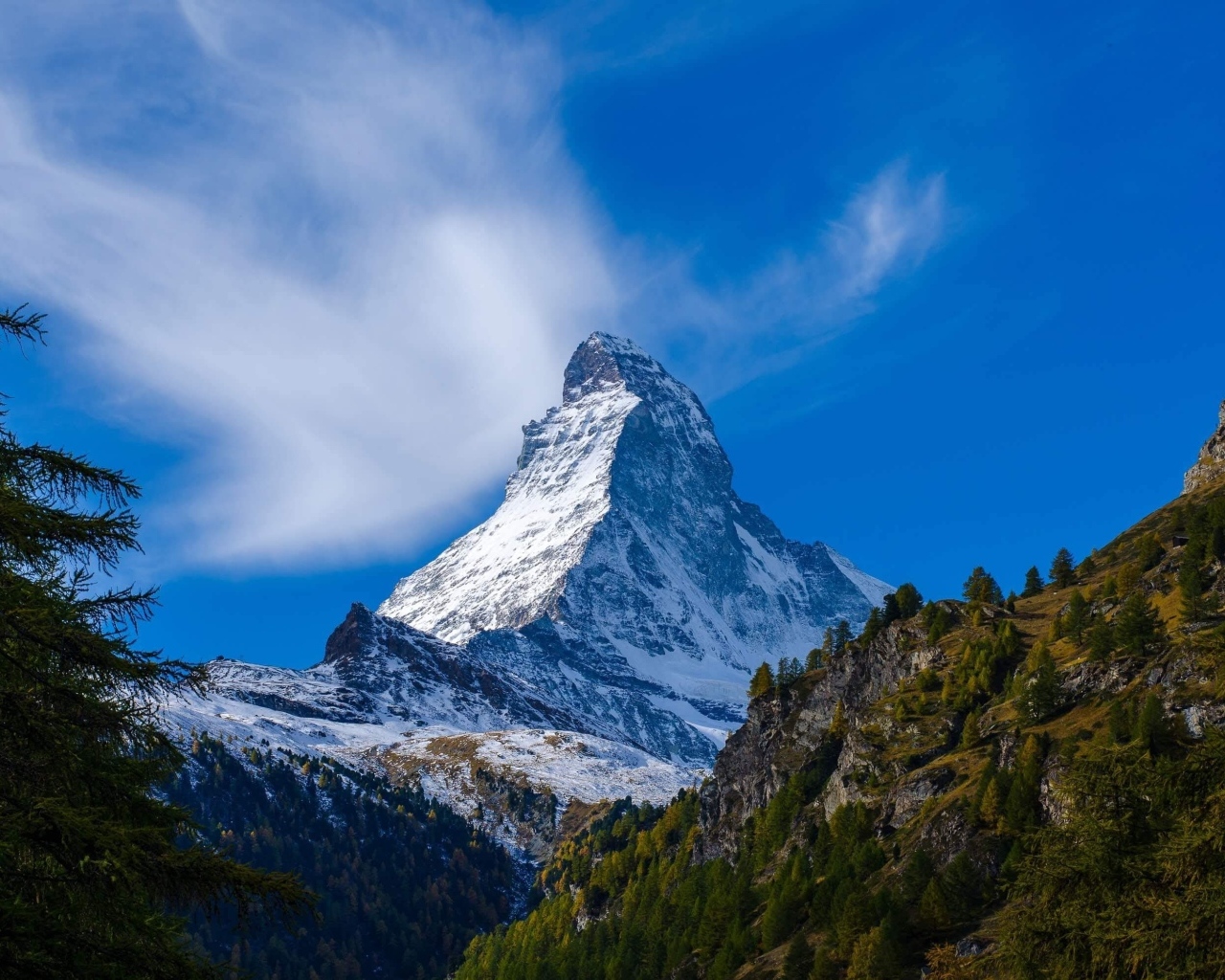 Вид на высокую заснеженную гору под голубым небом