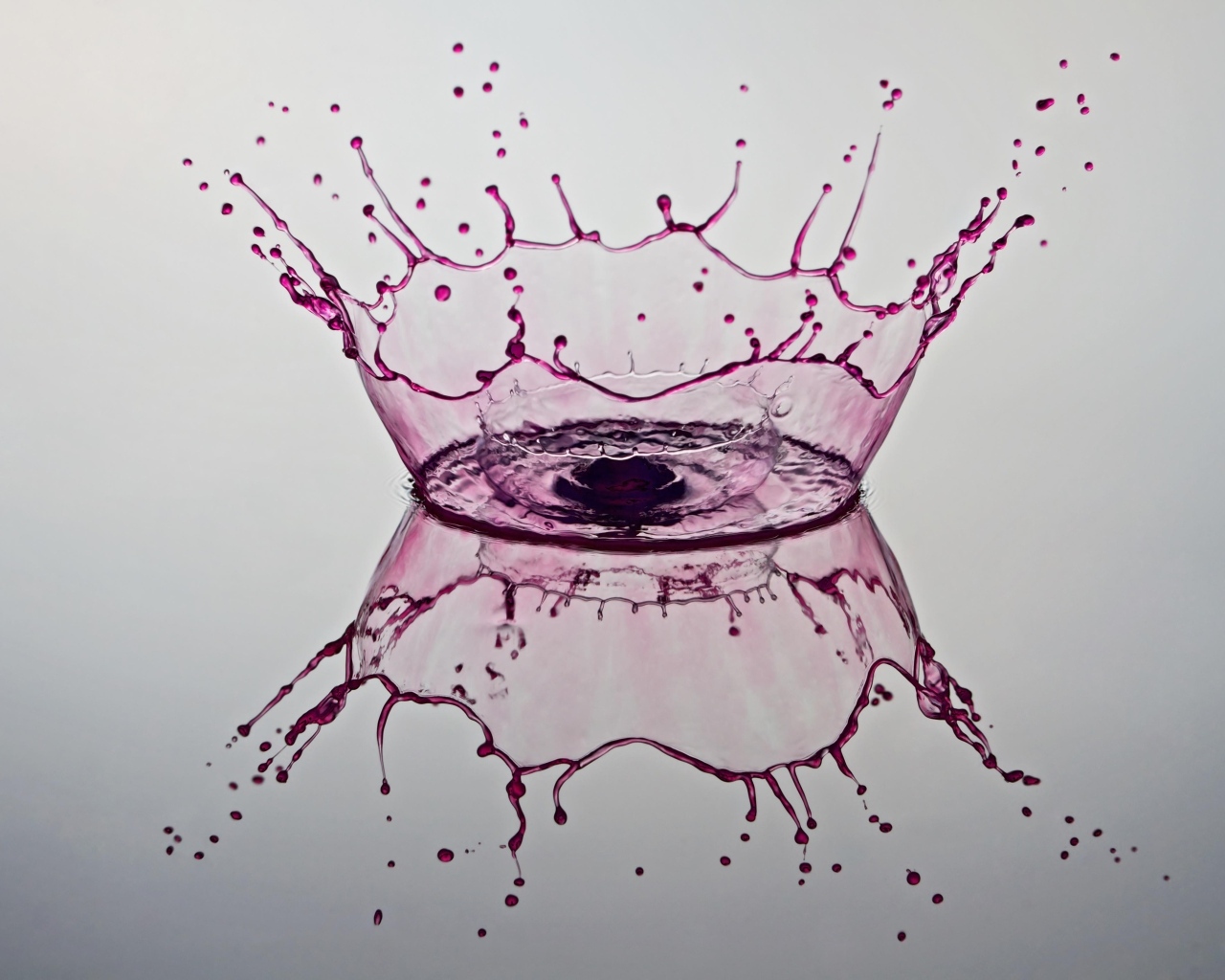 Красные брызги воды на сером фоне