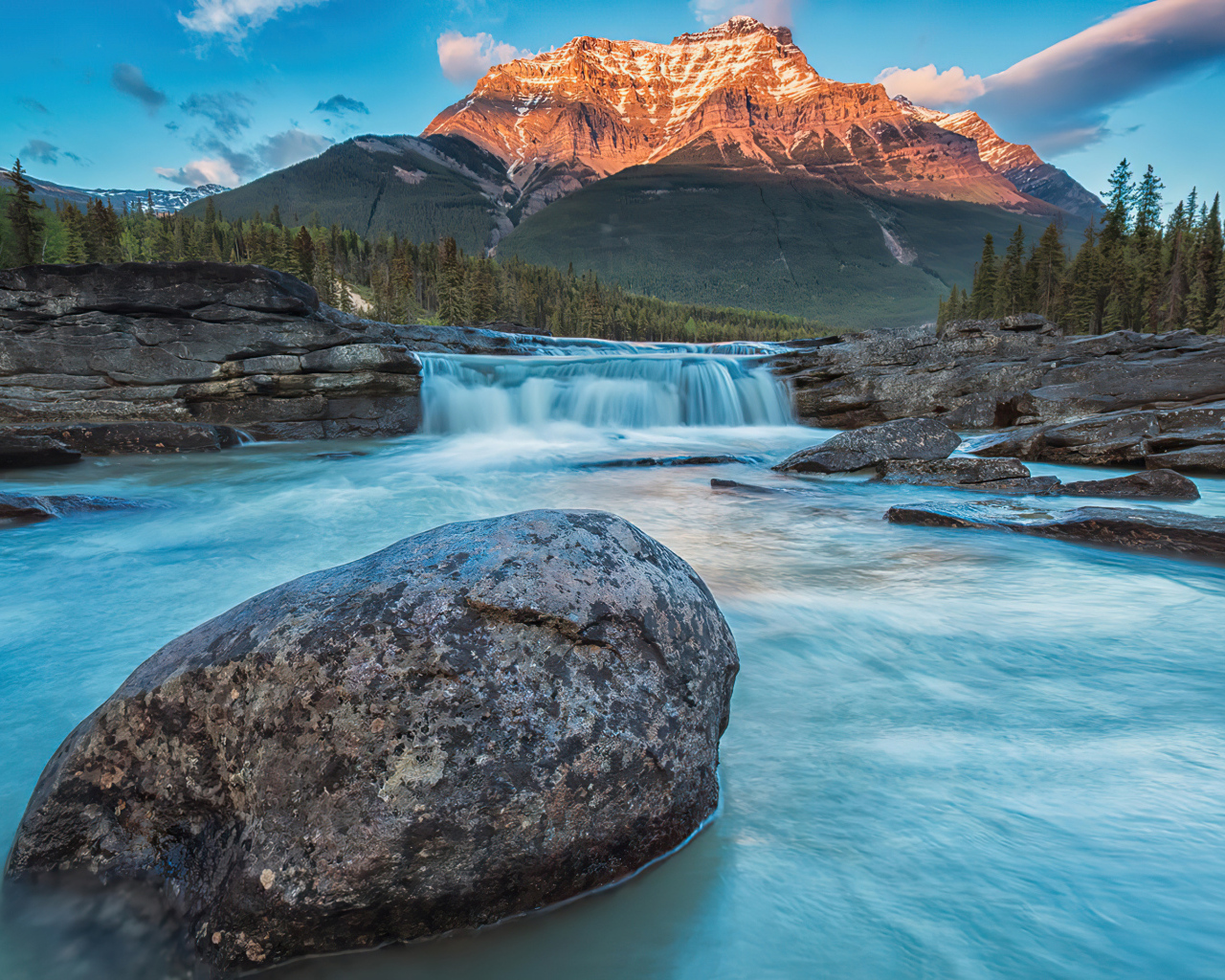 Большой камень лежит в реке у горы