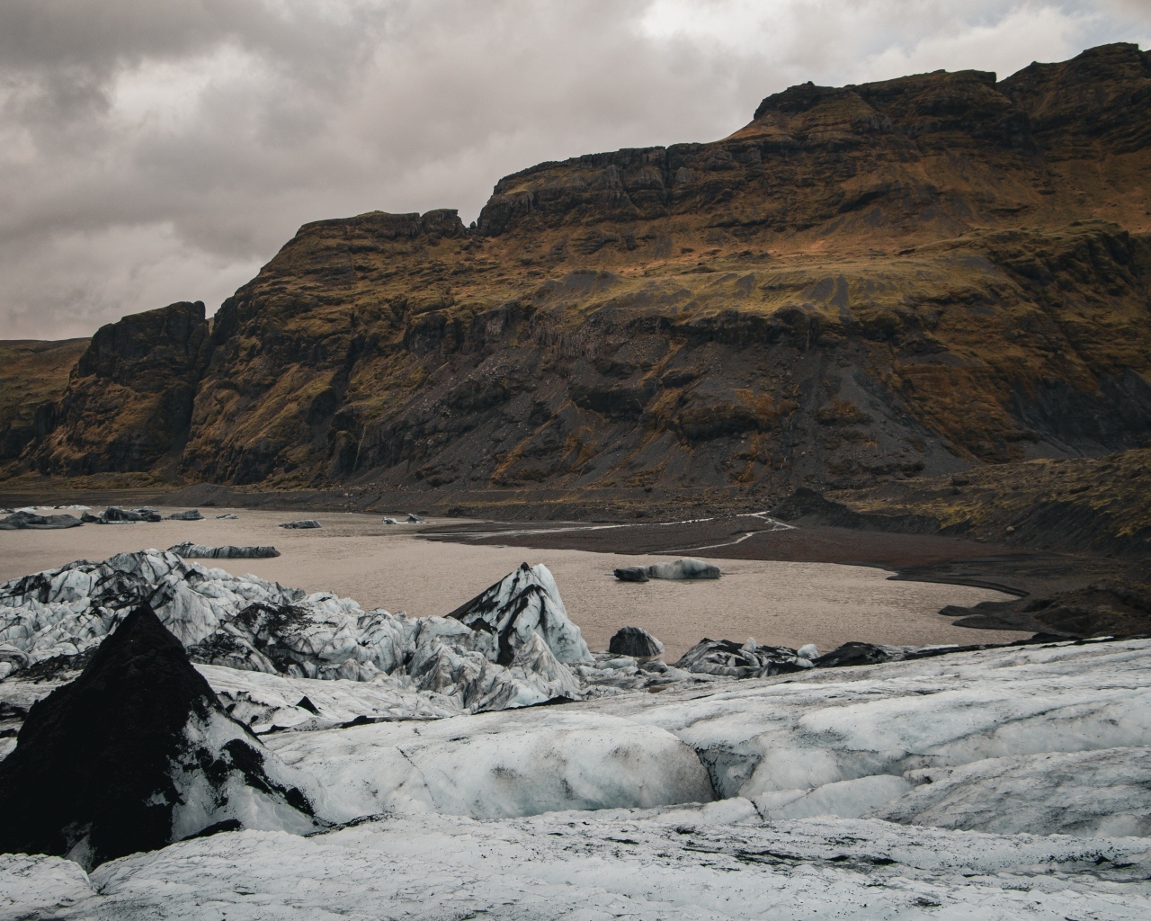 Холодный грязный снег на берегу моря у гор 
