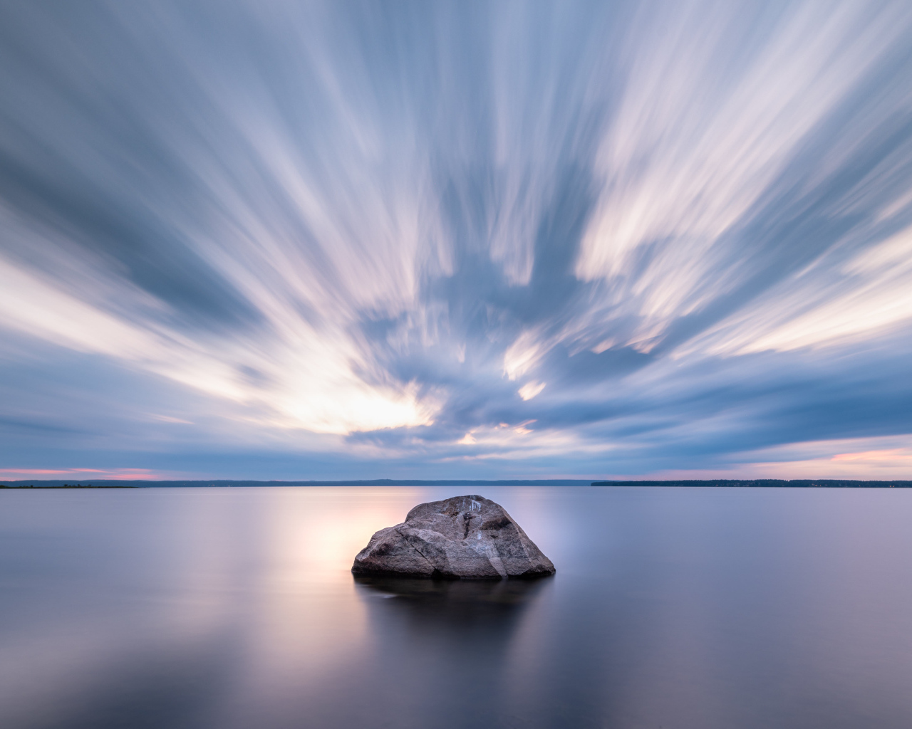 Большой камень в воде под красивым небом
