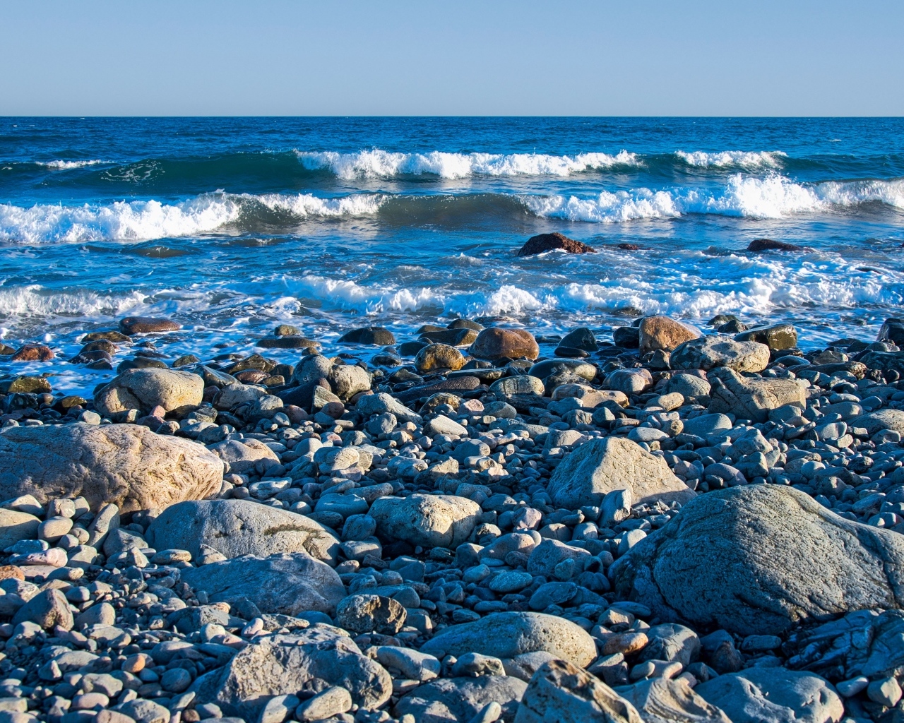 Большие камни на берегу моря с белыми волнами