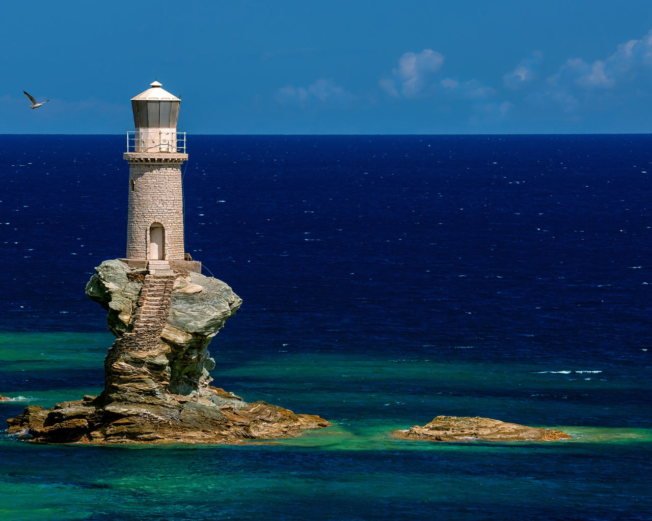 Старый маяк на каменном острове в море